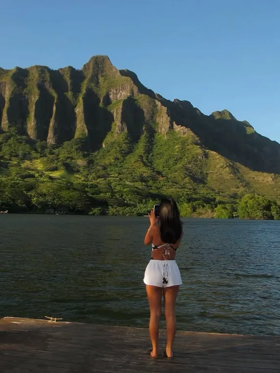 Person looking out over a green mountain lagoon