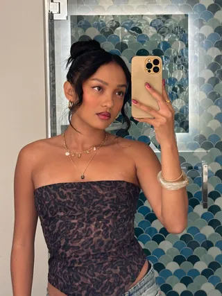 Creator taking a mirror selfie in a tiled bathroom